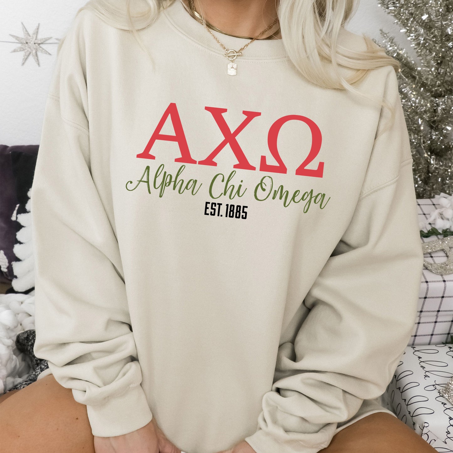 a woman sitting on a bed wearing a sweatshirt