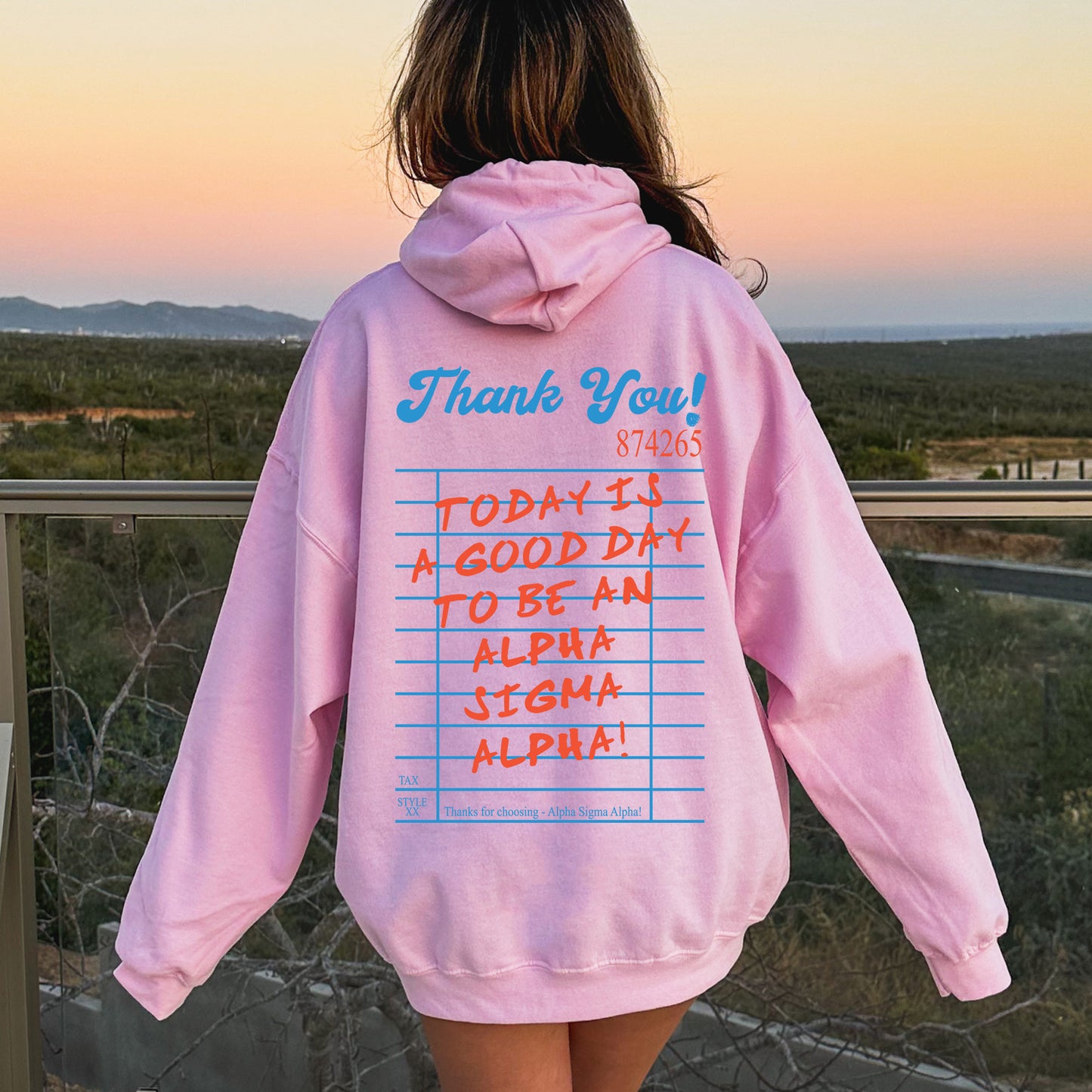 a person wearing a pink hoodie with writing on it
