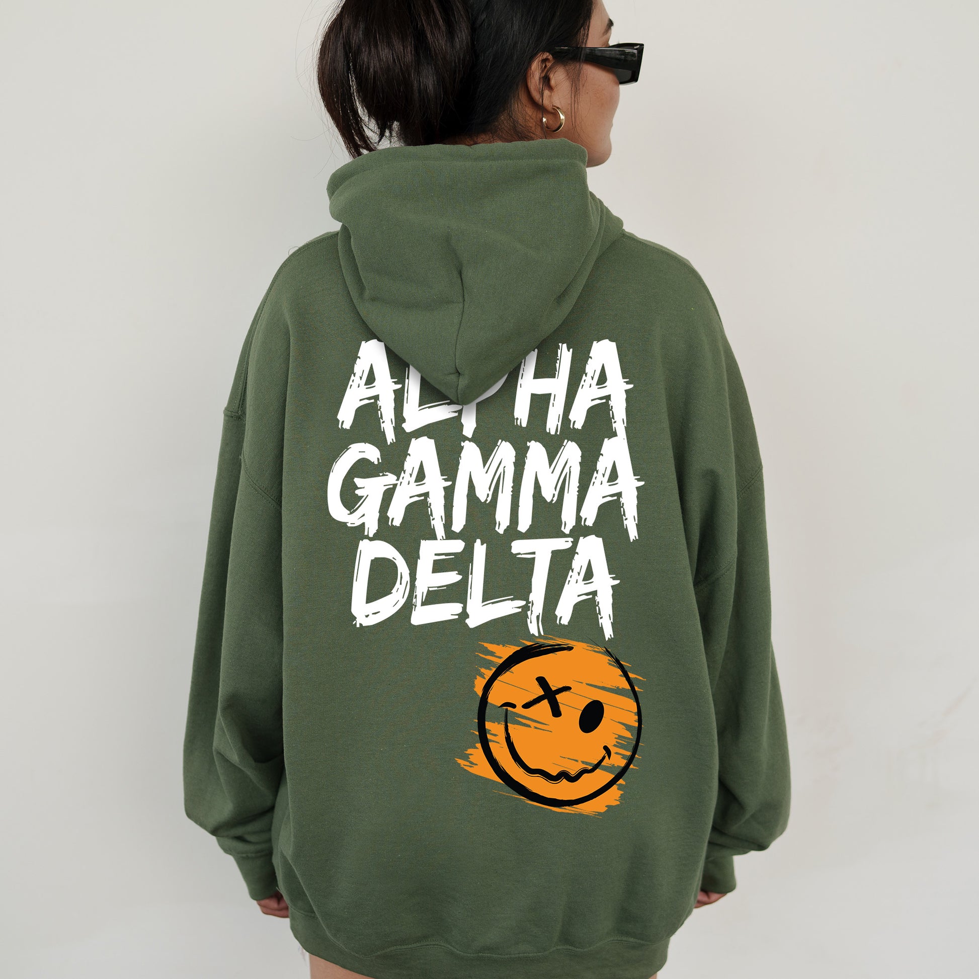 a woman wearing a green hoodie with a smiley face on it