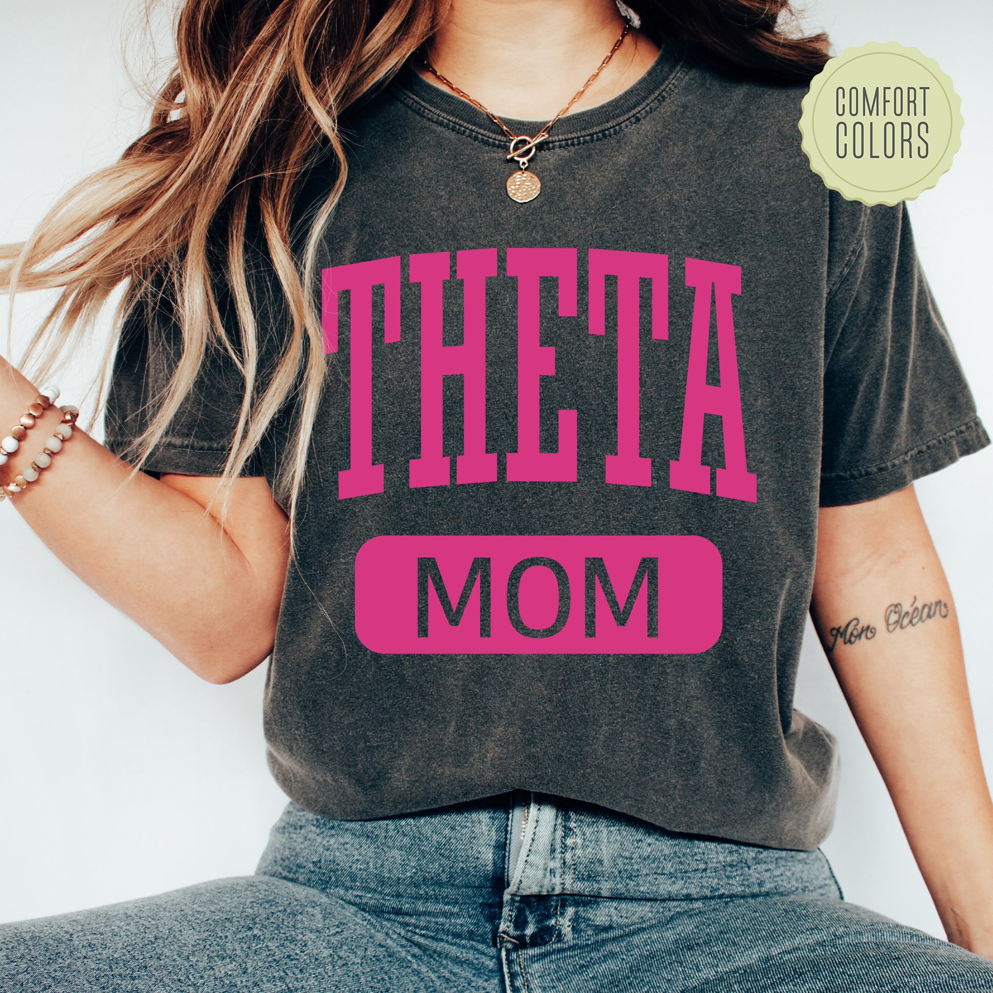 a woman wearing a t - shirt that says theta mom