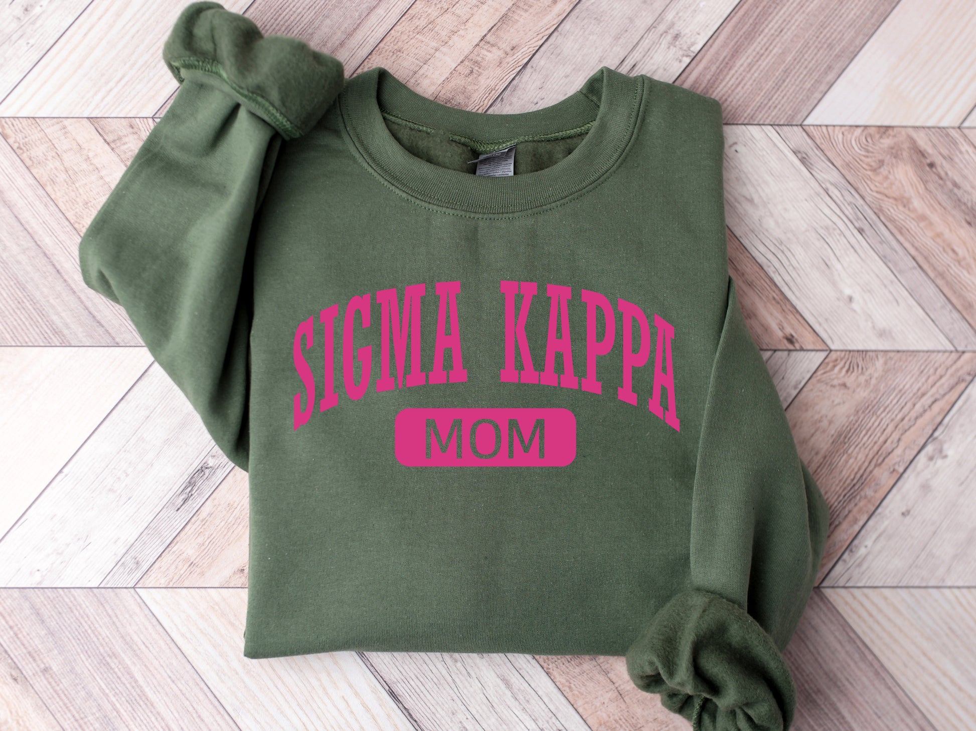 a green sweatshirt with pink lettering on it