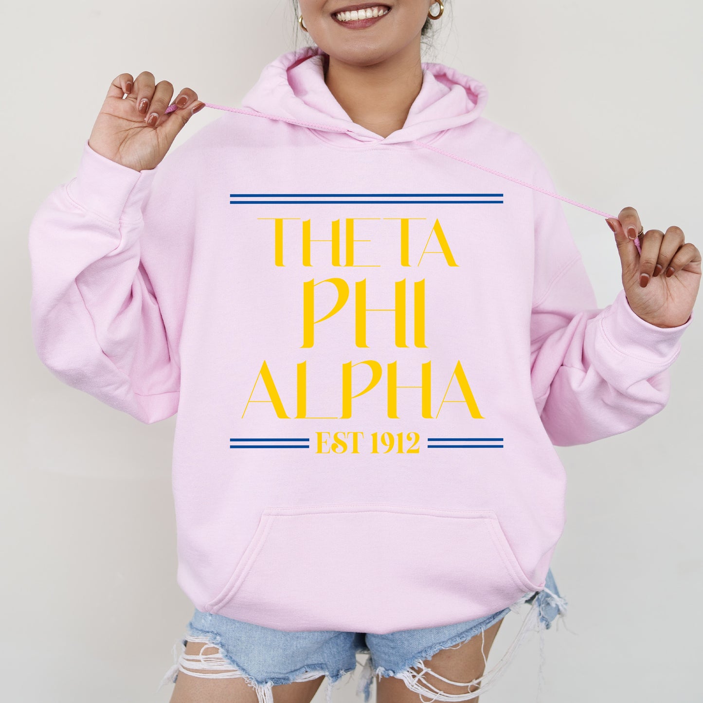 a woman wearing a pink hoodie with the words, the fa phi alpha