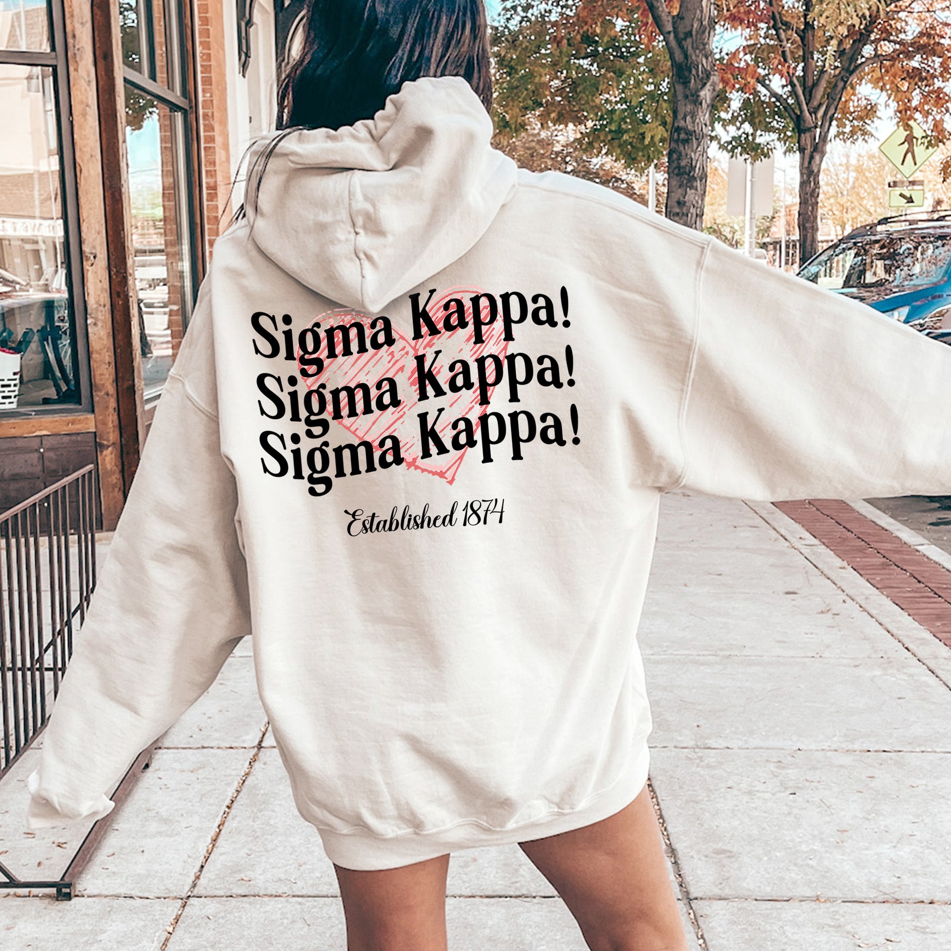 a woman in a white hoodie is walking down the street