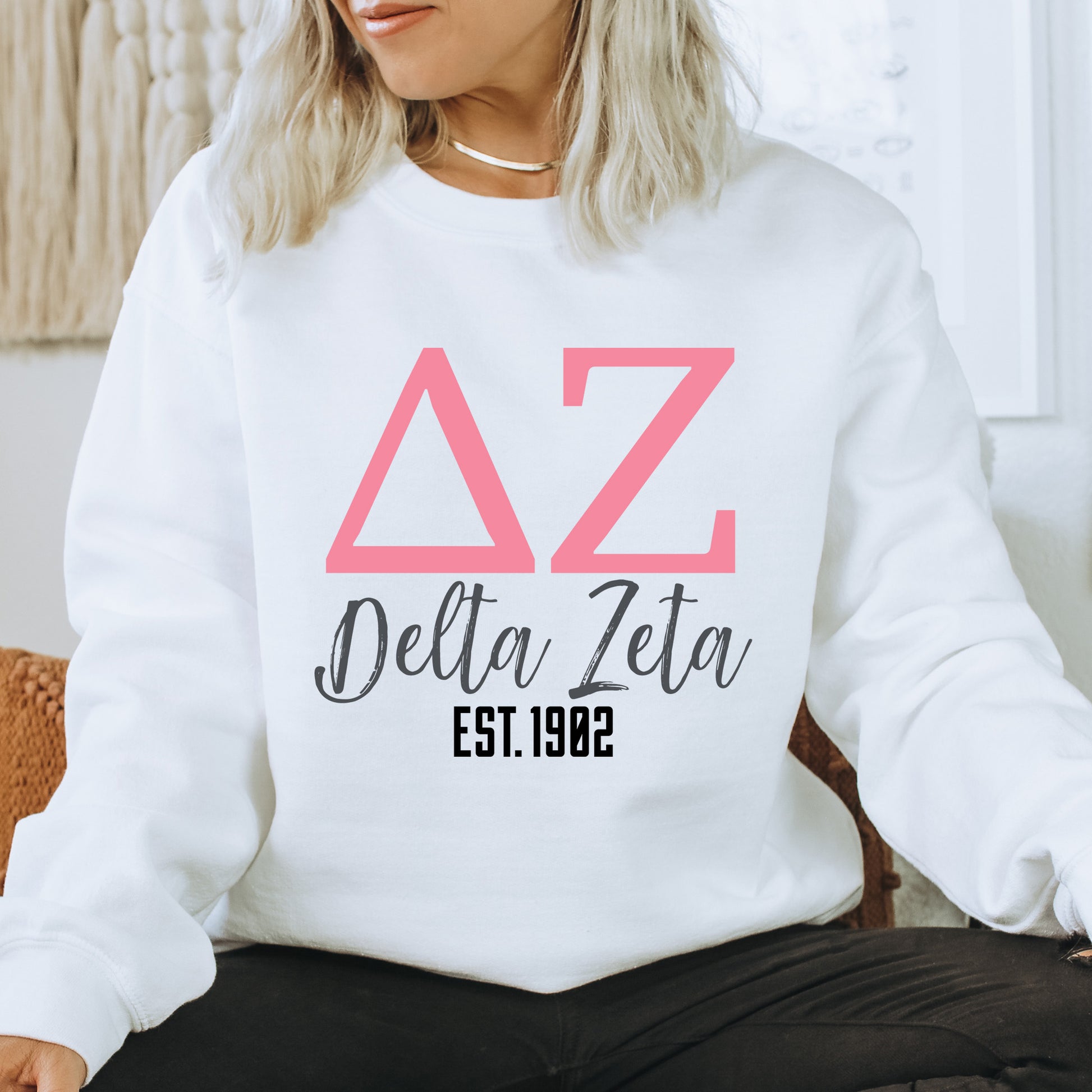 a woman sitting on a chair wearing a white sweatshirt
