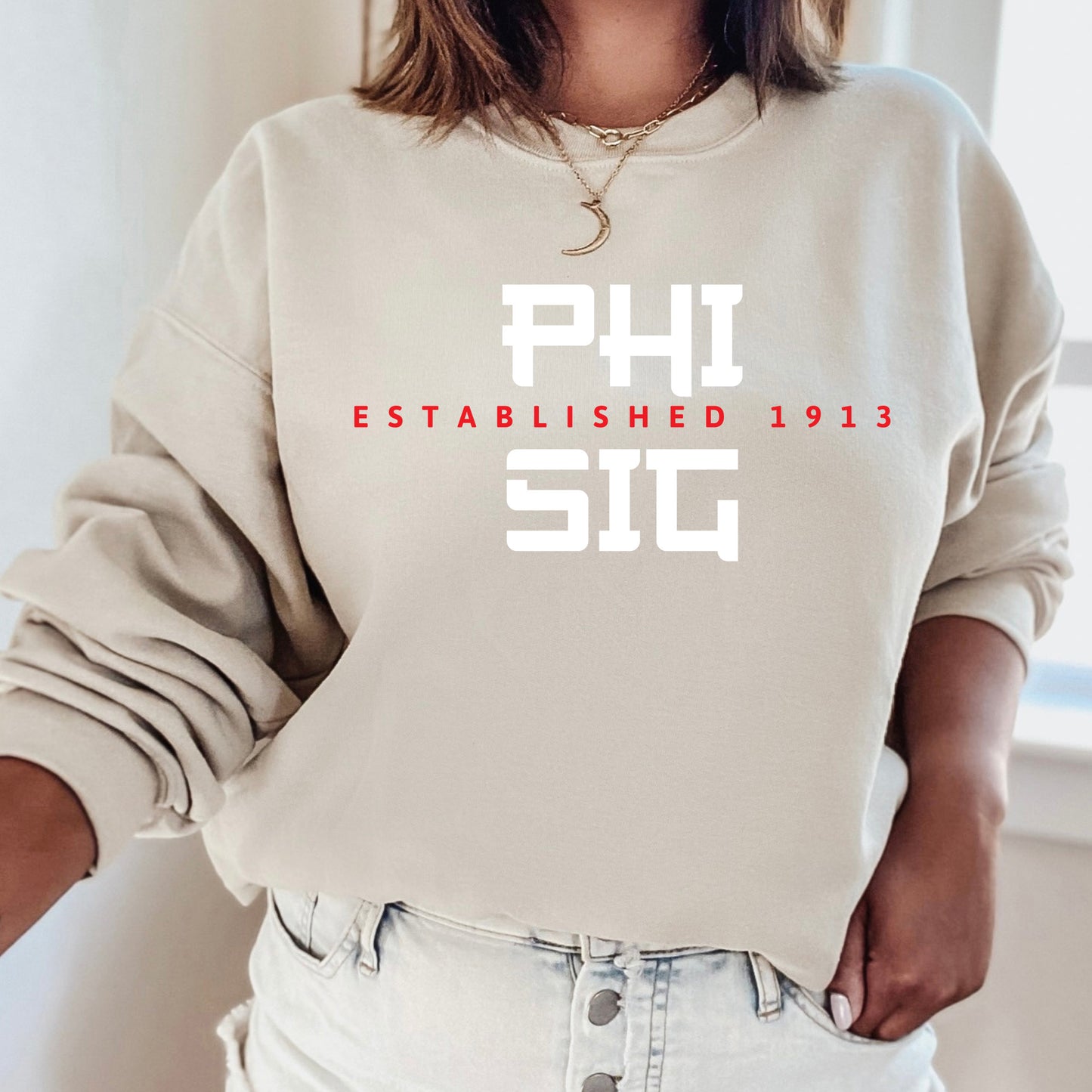 a woman wearing a sweatshirt that says phi established 1932
