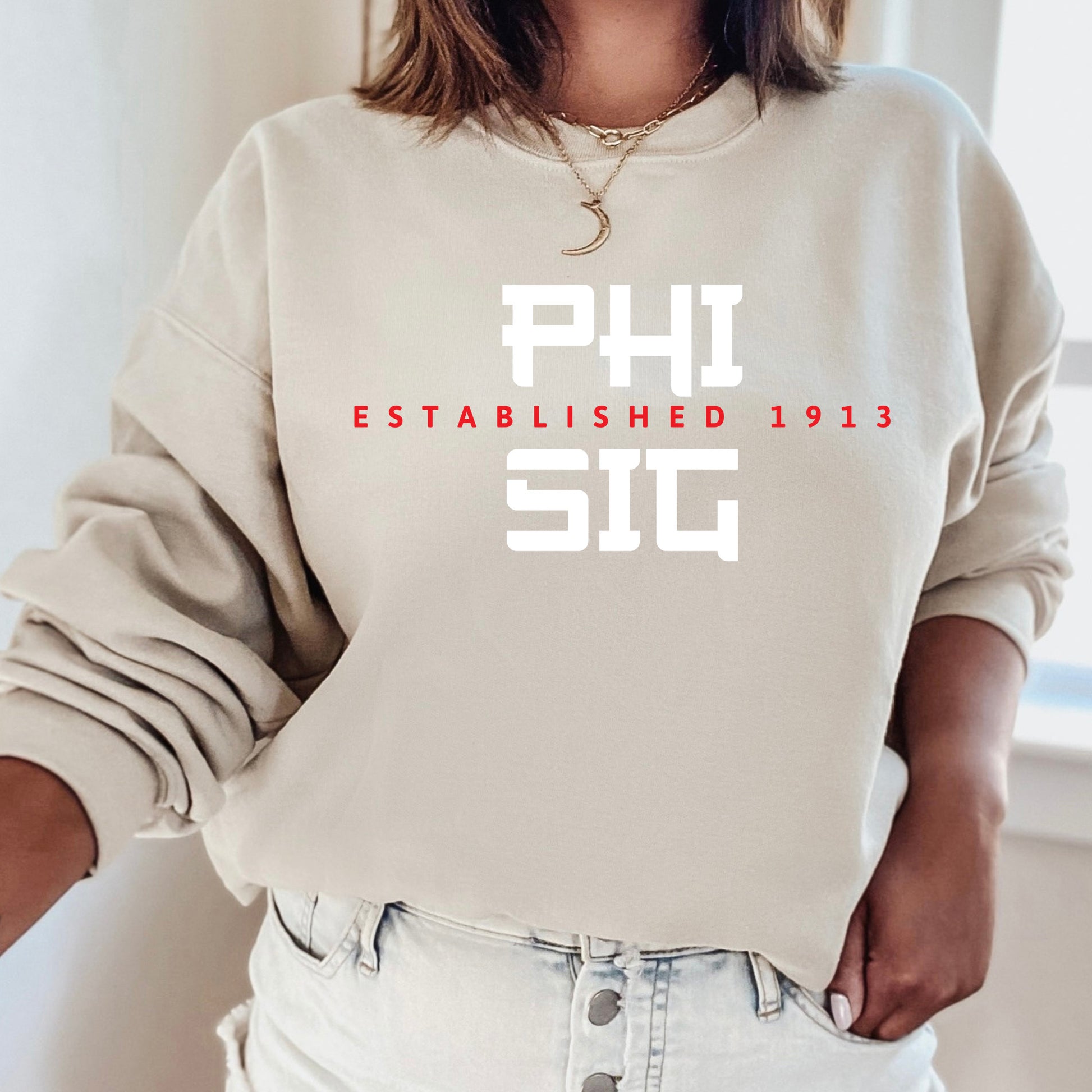 a woman wearing a sweatshirt that says phi established 1932