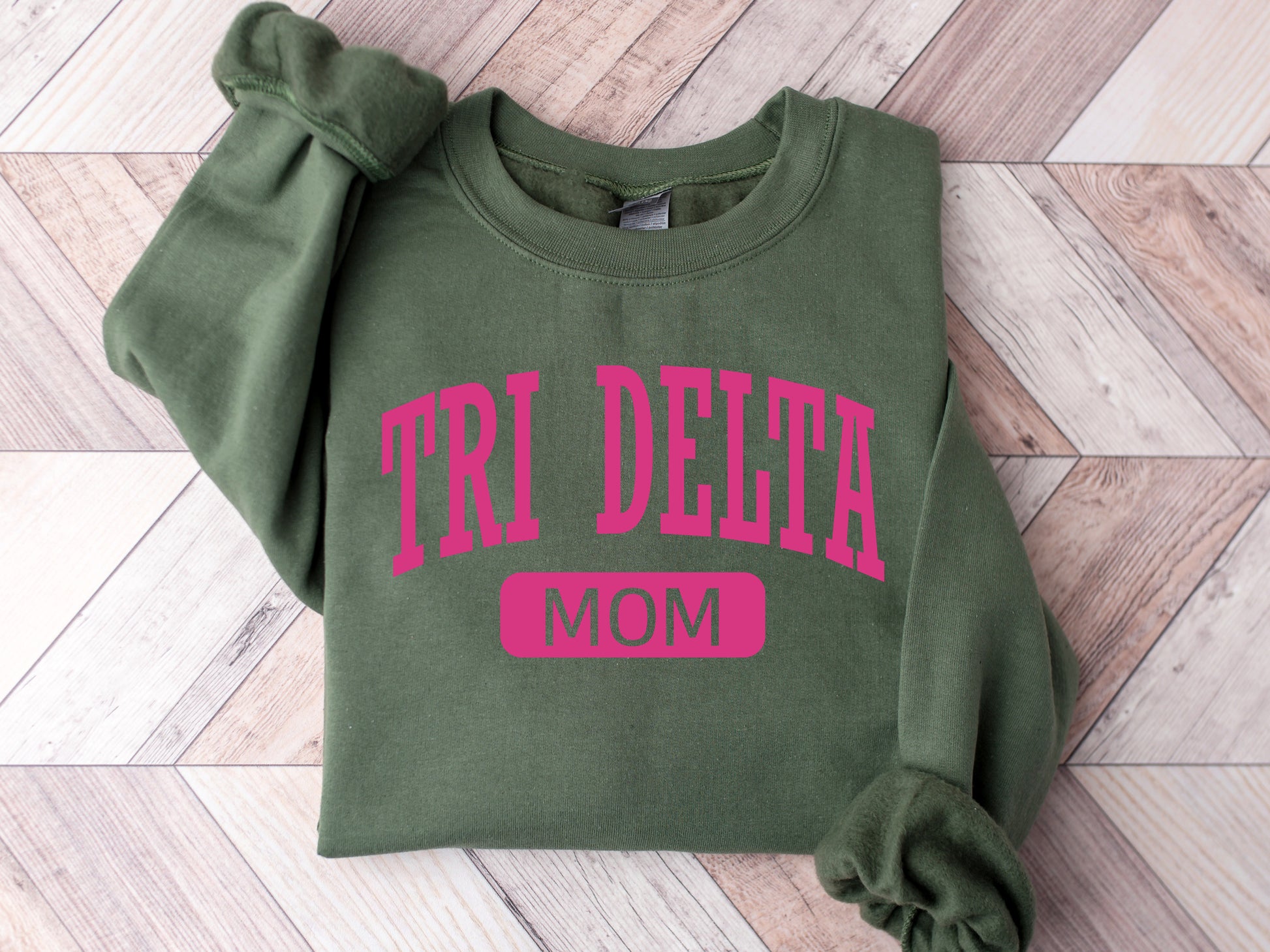 a green sweatshirt with the words tri delta mom on it