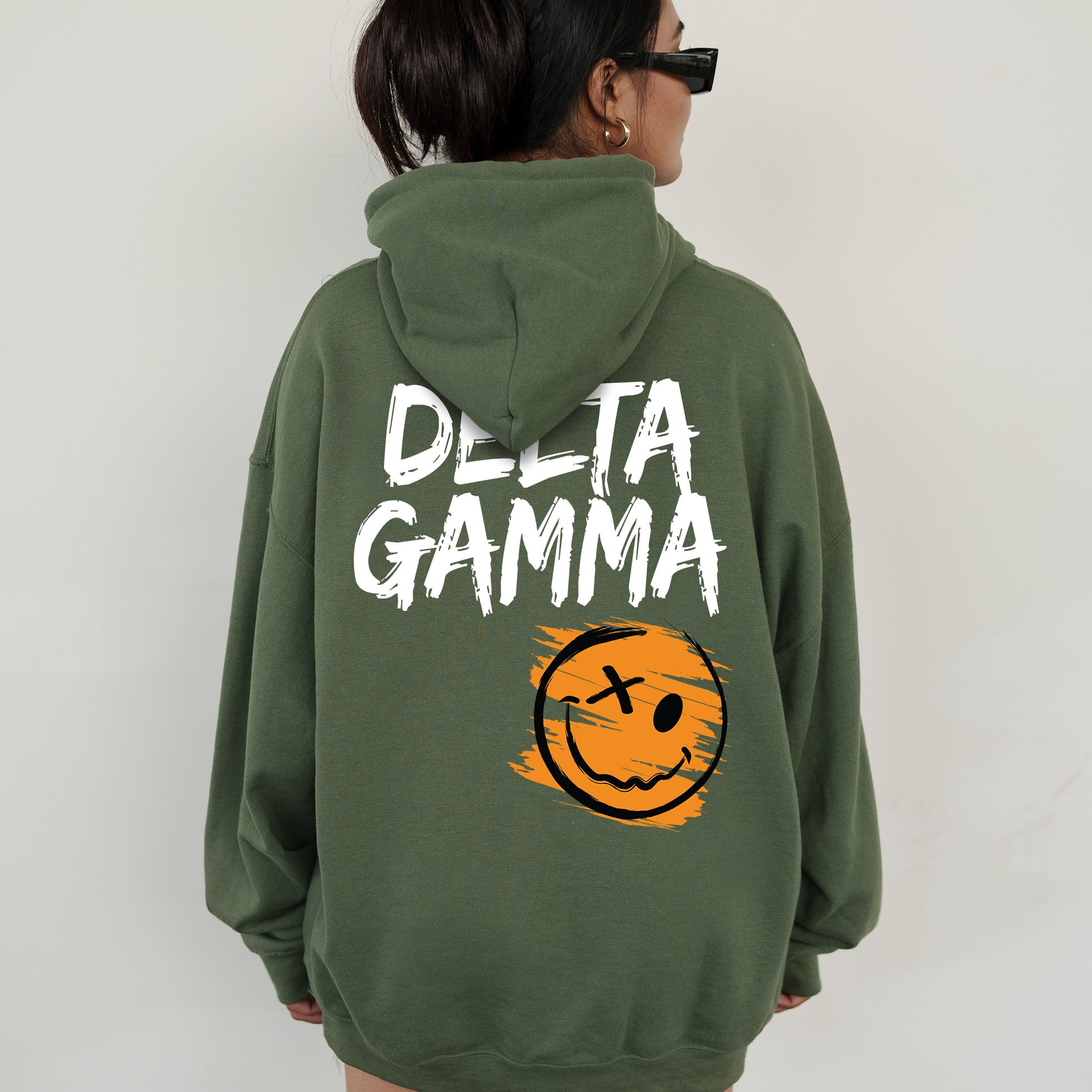 a woman wearing a green sweatshirt with a smiley face on it