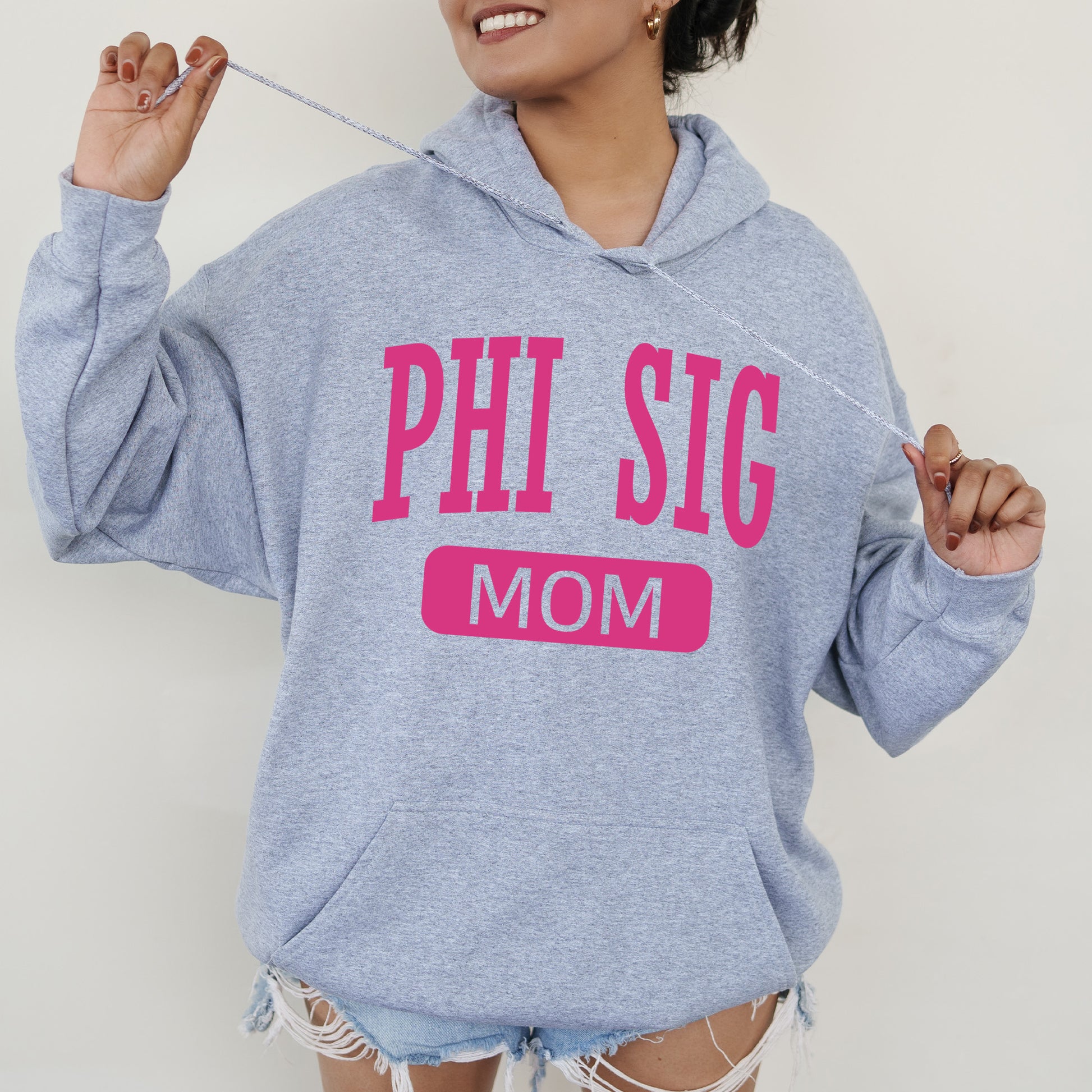 a woman wearing a sweatshirt that says phi sig mom