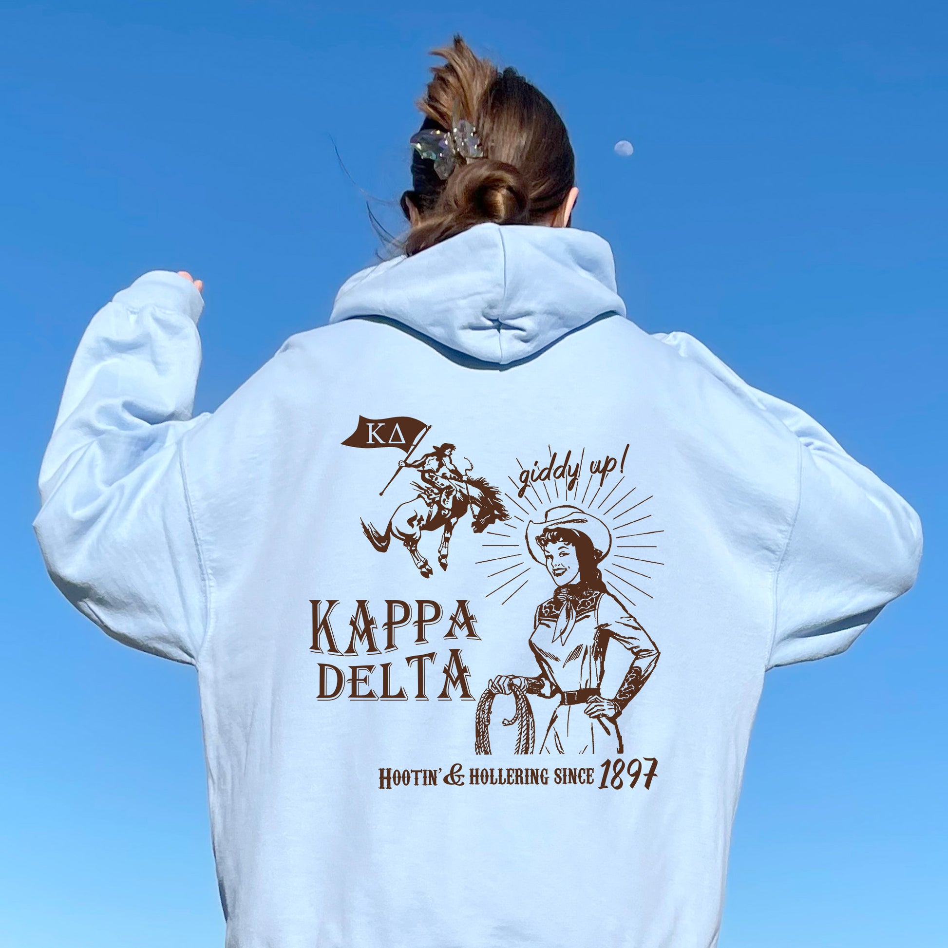 a woman in a white hoodie is flying a kite
