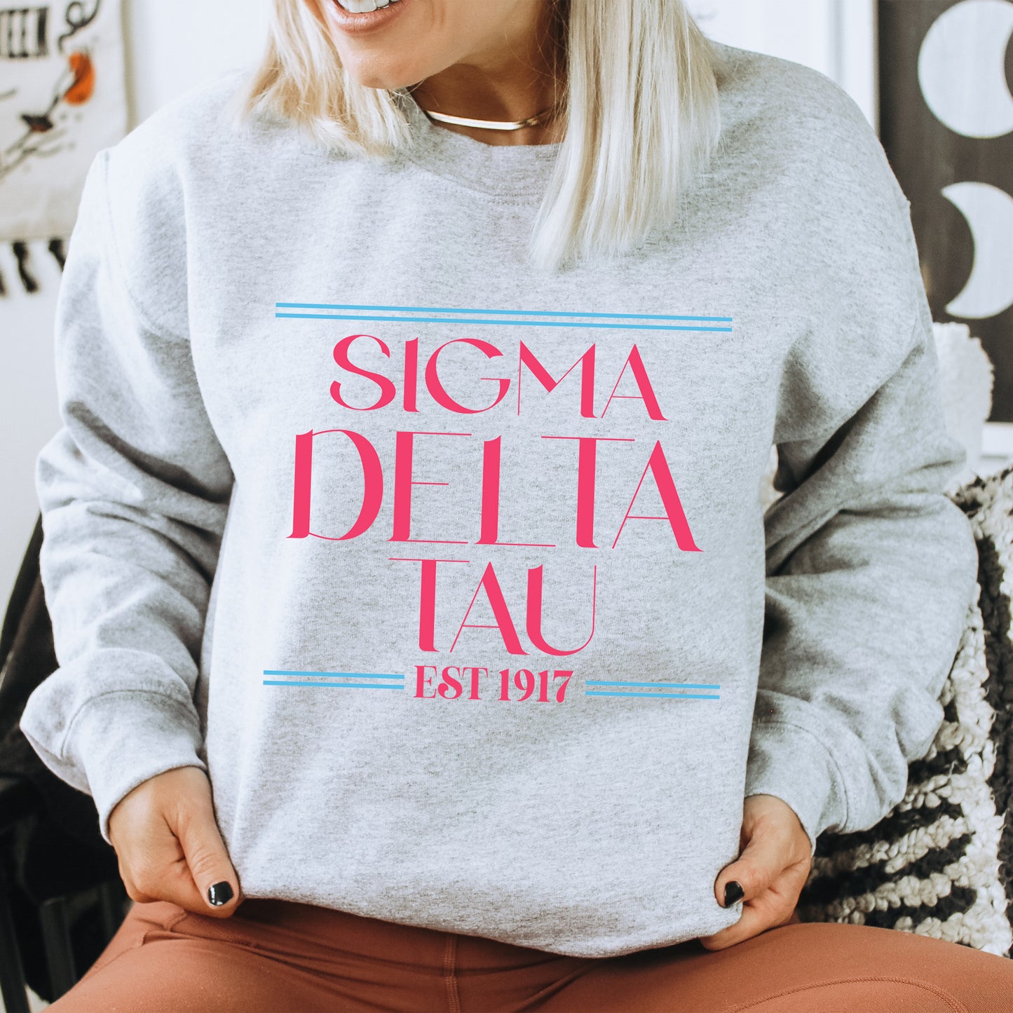 a woman sitting on a chair wearing a sweatshirt