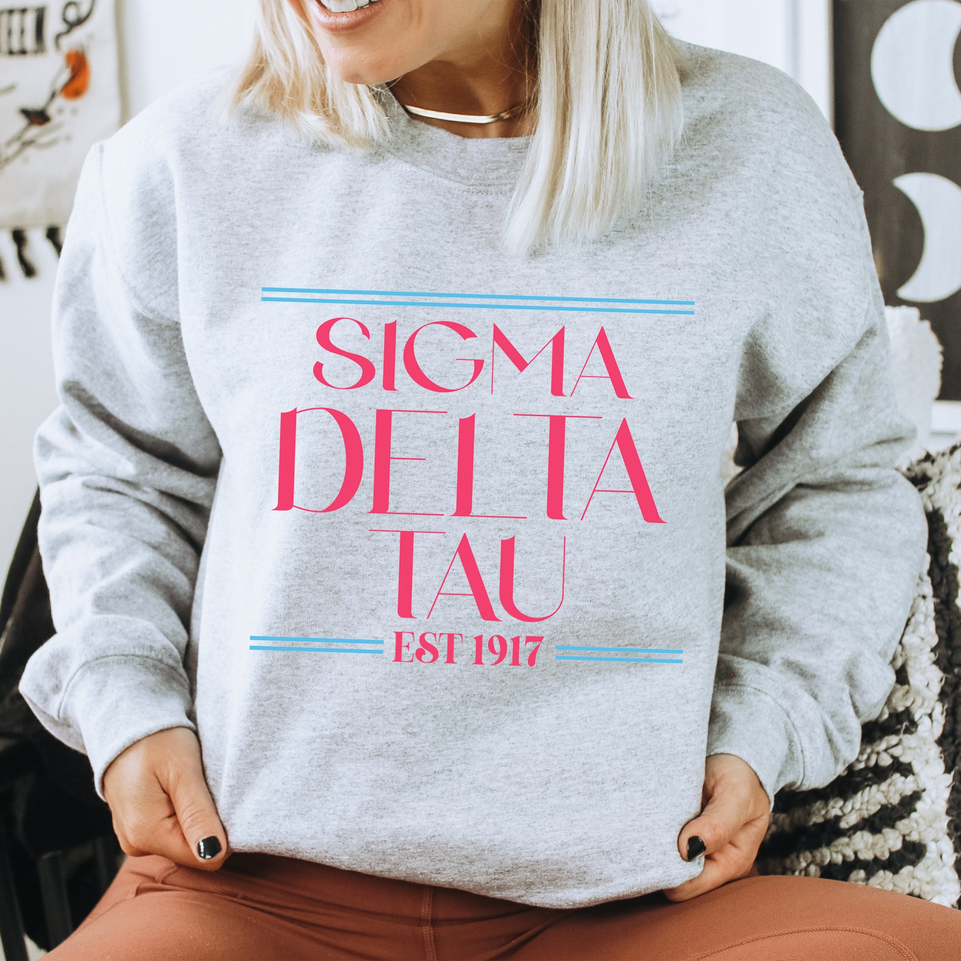a woman sitting on a chair wearing a sweatshirt