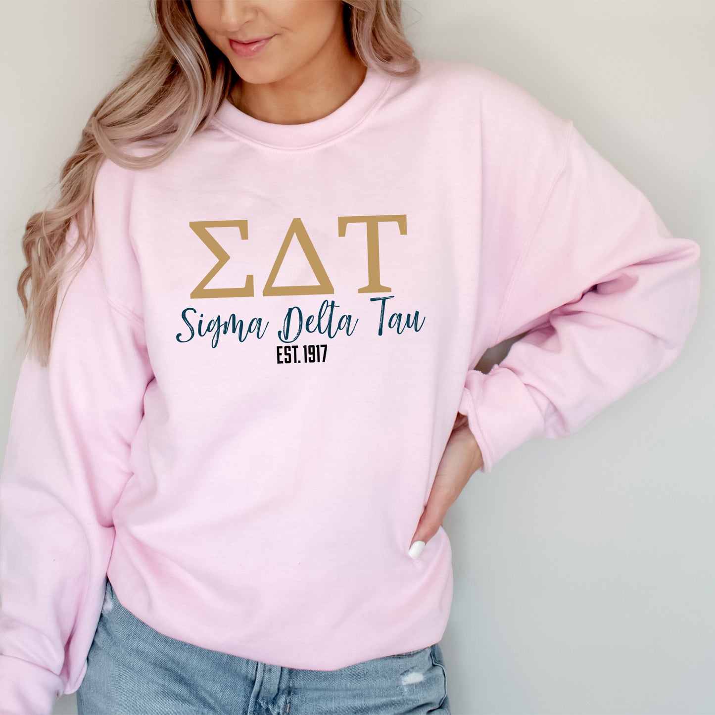 a woman wearing a pink sweatshirt and jeans