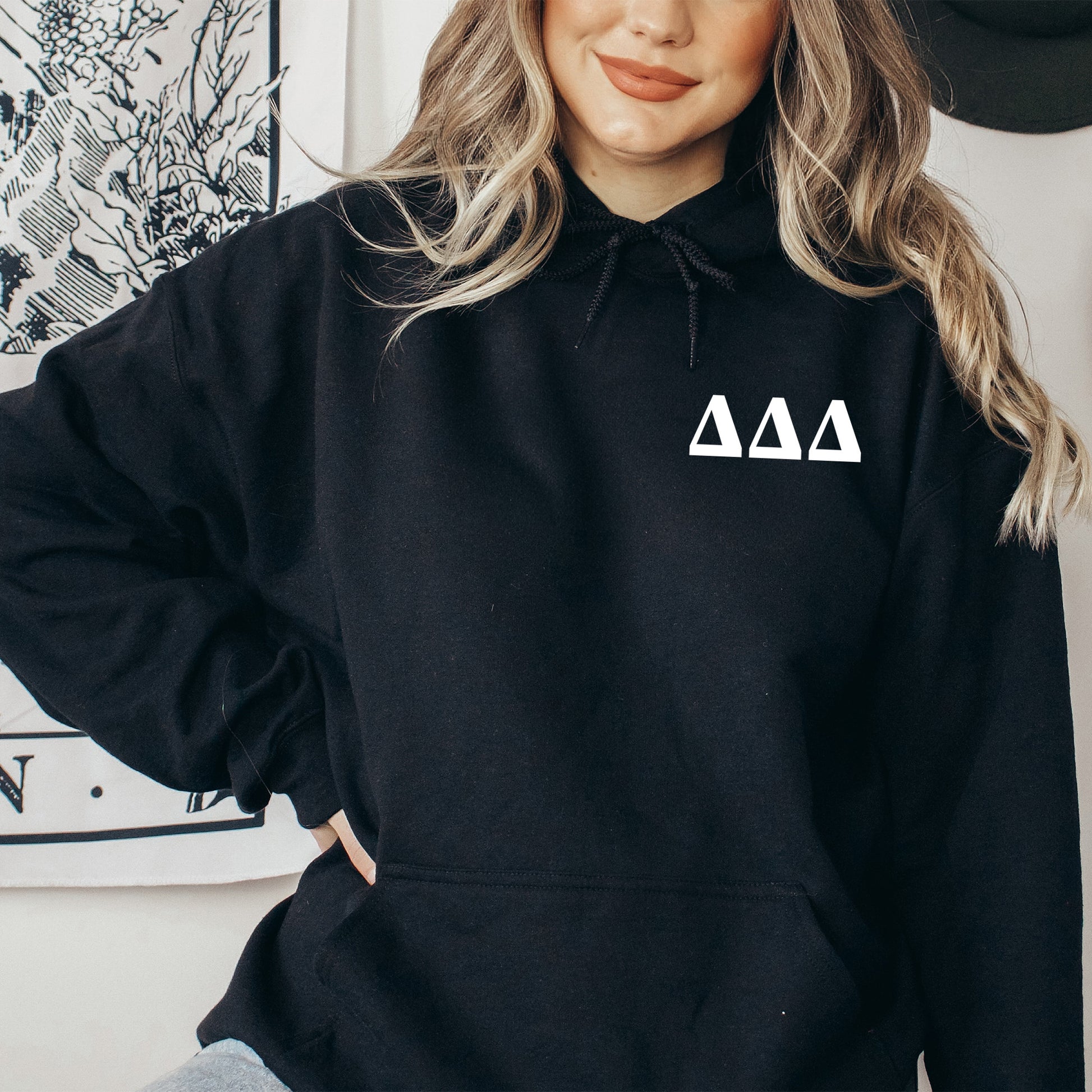 a woman wearing a black hoodie with a triangle on it