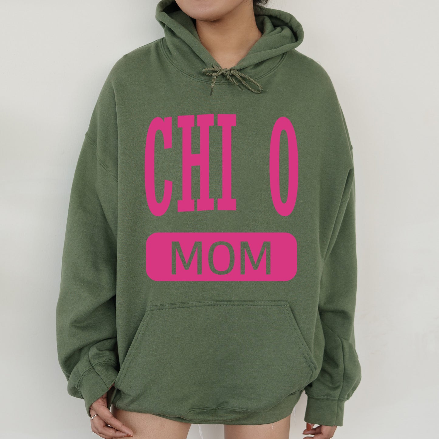 a woman wearing a green hoodie with pink letters on it