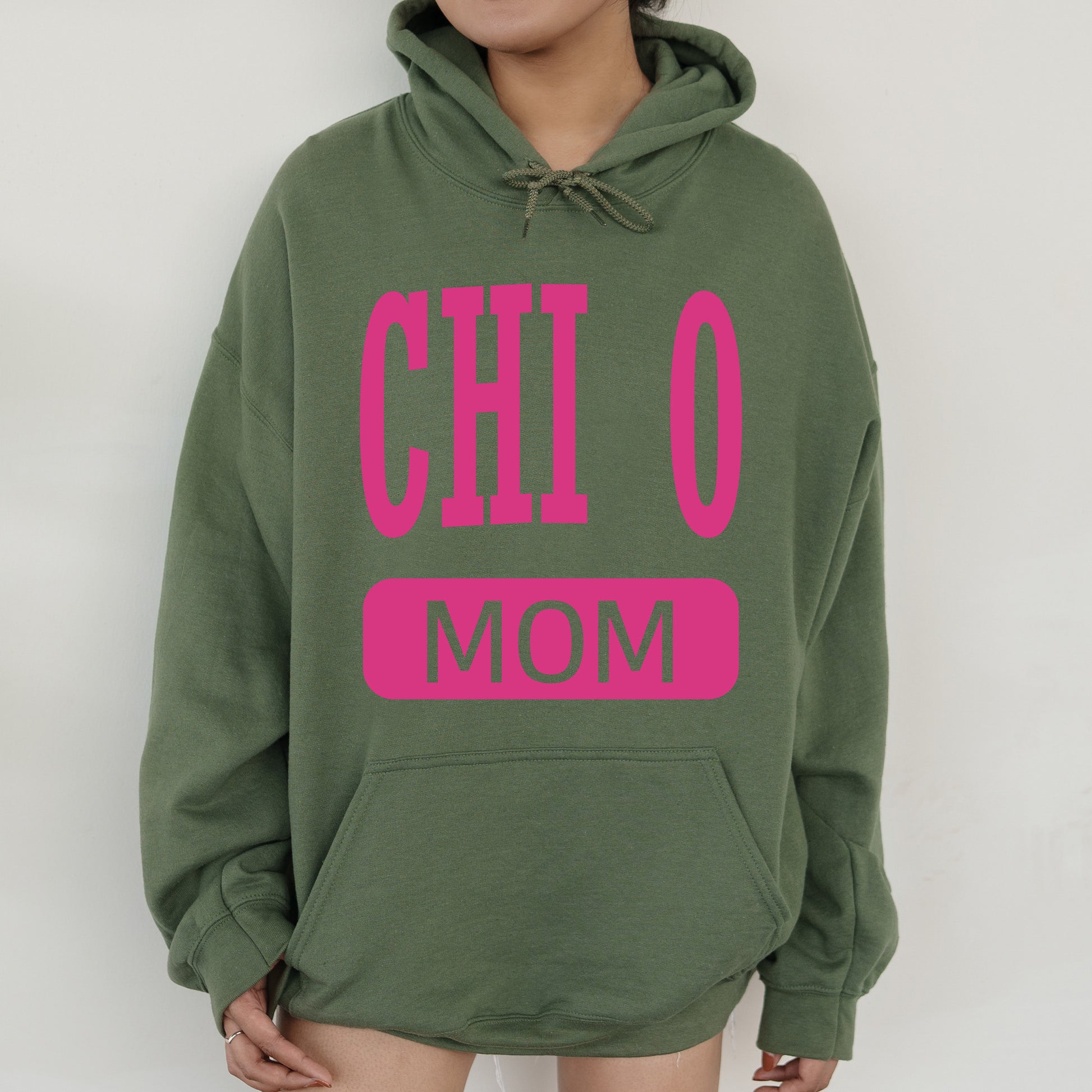 a woman wearing a green hoodie with pink letters on it