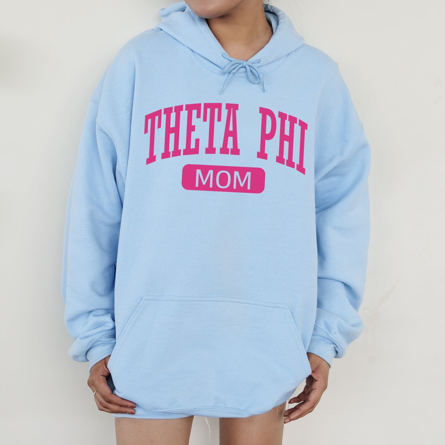 a woman wearing a blue hoodie with the word theta phi on it