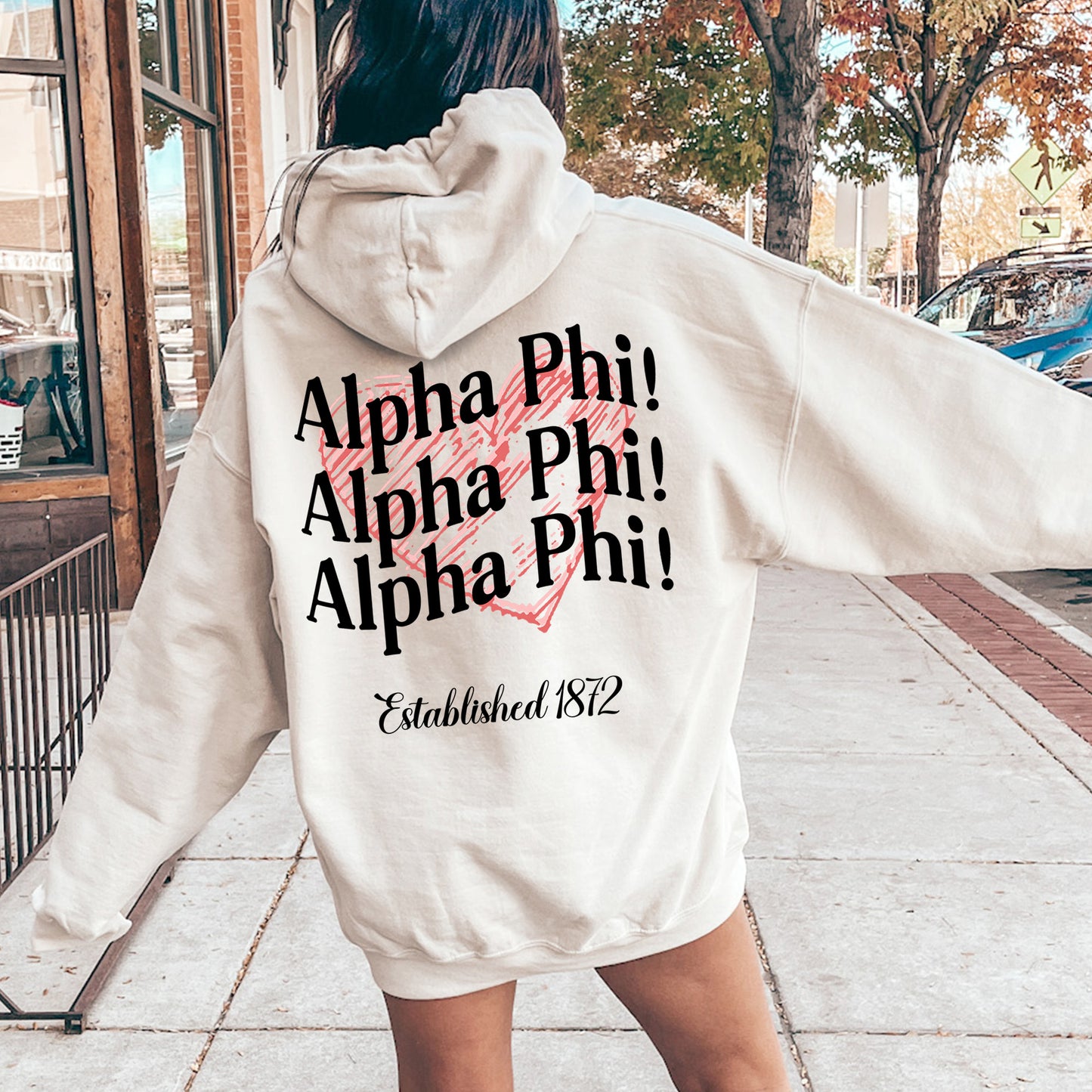 a woman in a white hoodie is walking down the street