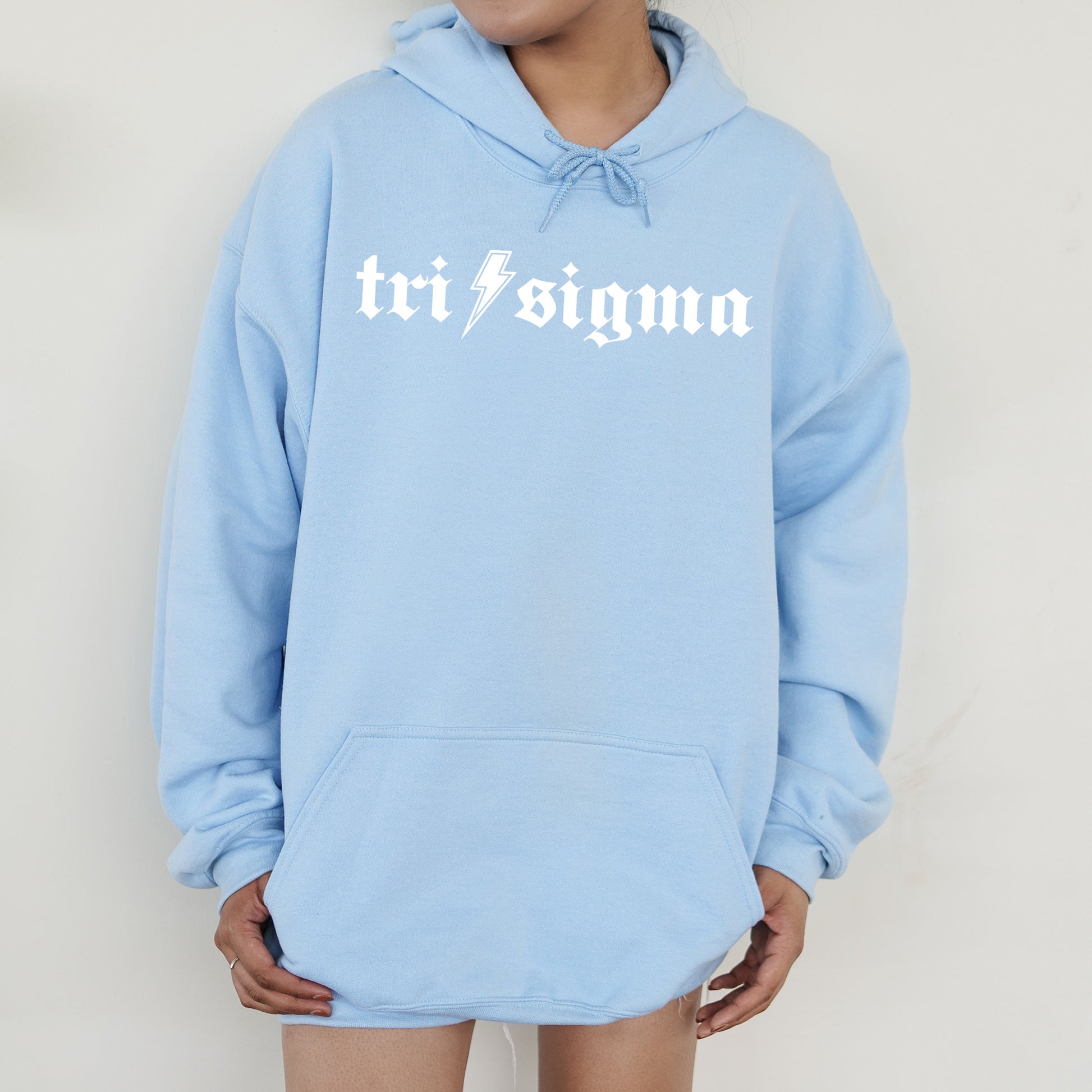 a woman wearing a blue sweatshirt with the word tri stigma on it