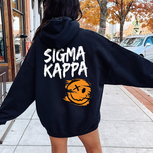 a woman walking down a sidewalk wearing a black hoodie