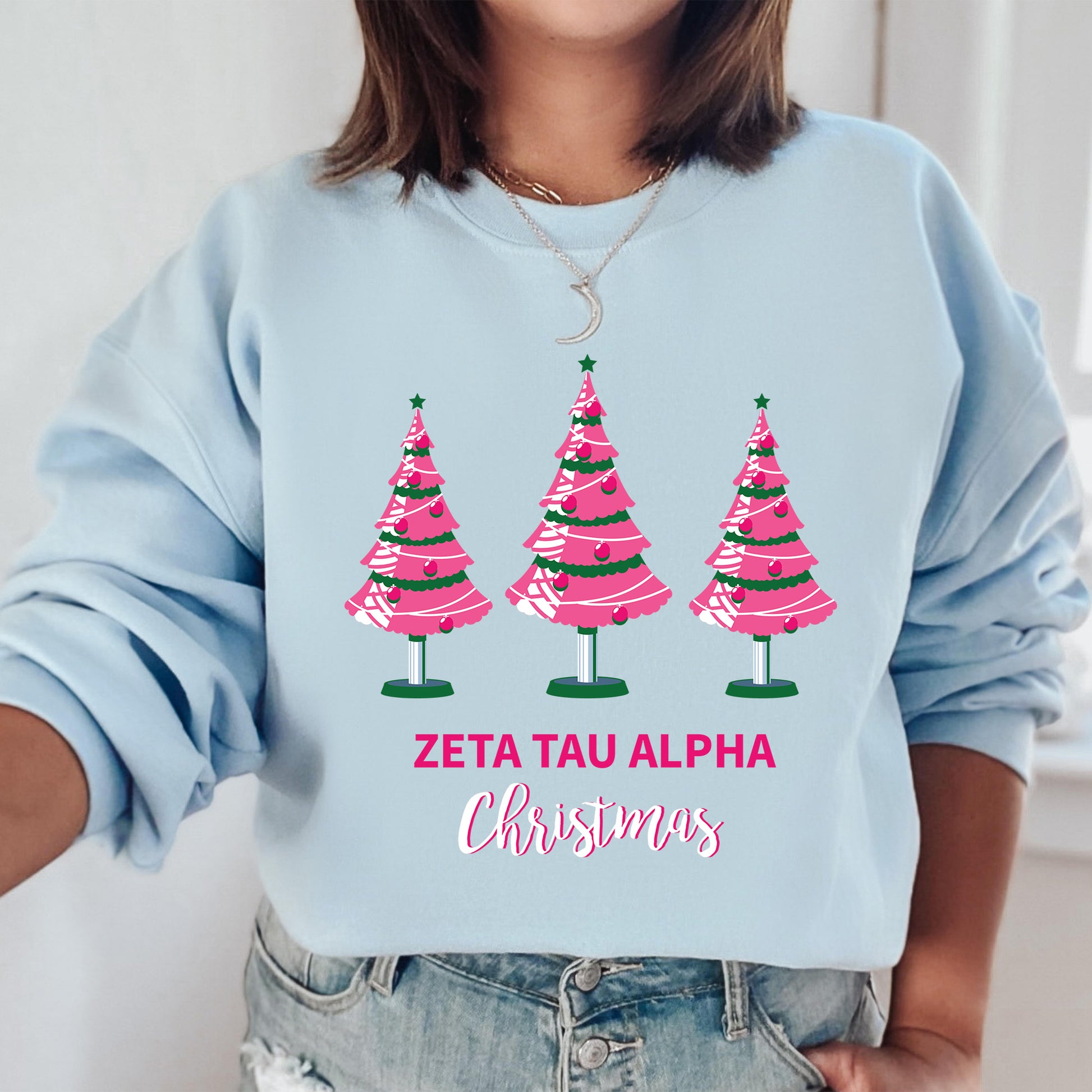 a woman wearing a blue sweater with pink christmas trees on it