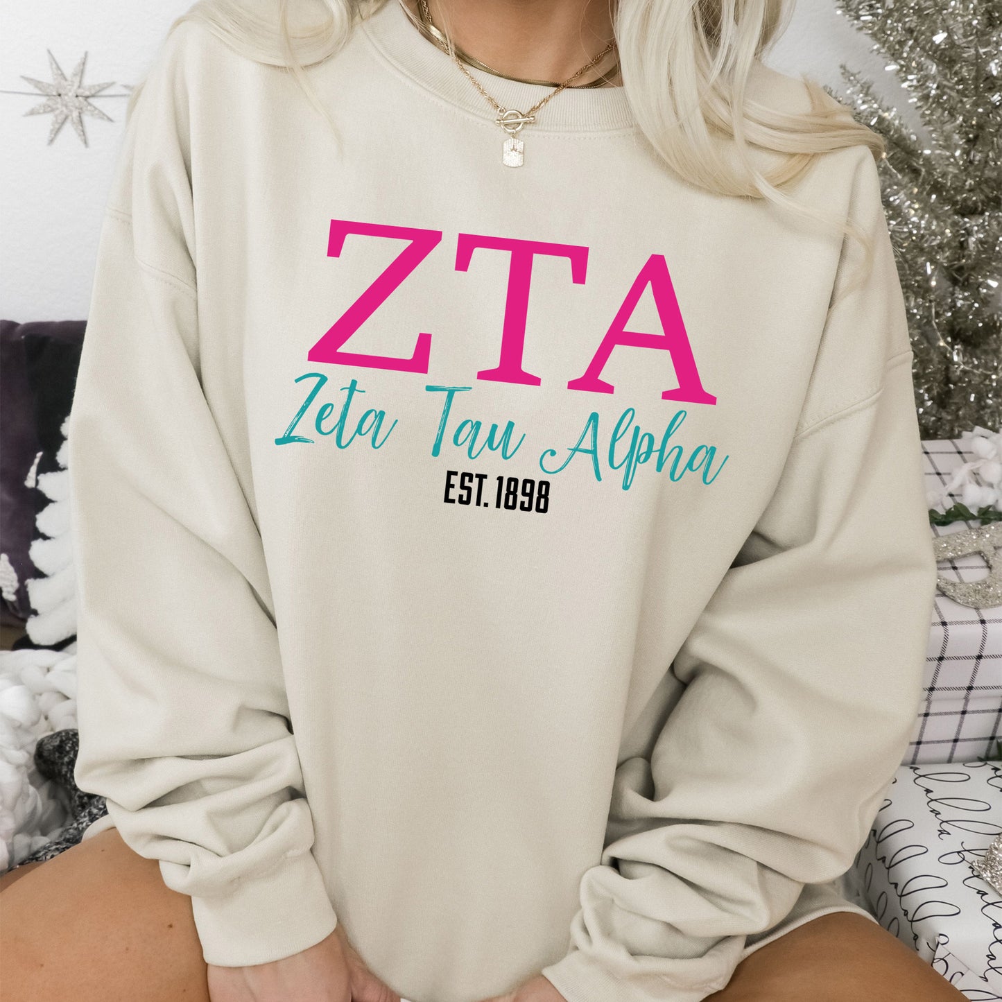 a woman sitting on a bed wearing a sweatshirt