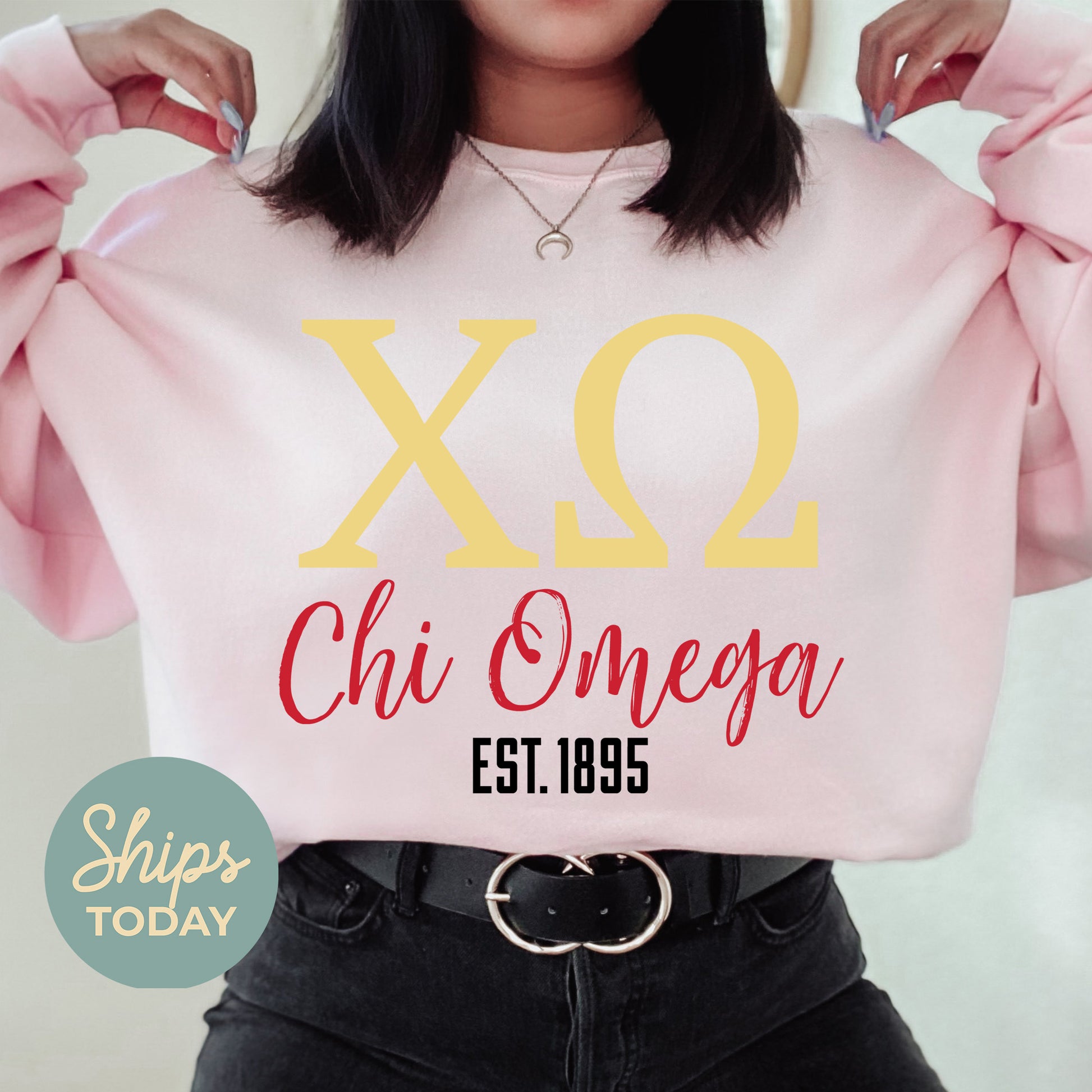 a woman wearing a pink sweatshirt with a yellow x2 chi onega on it